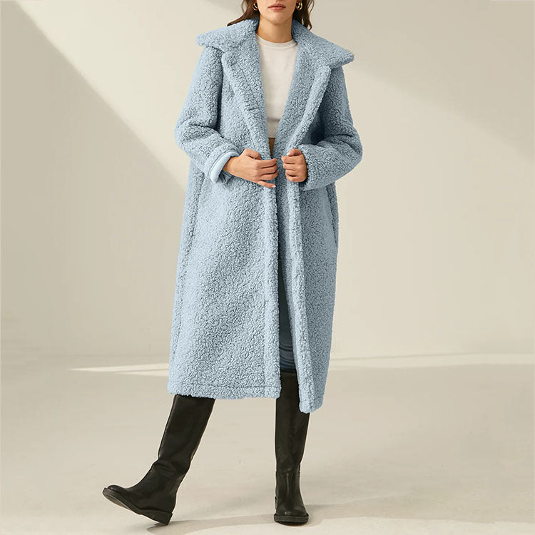 Mujer con el abrigo largo polar Ysandre en azul claro, con solapa amplia y botas negras