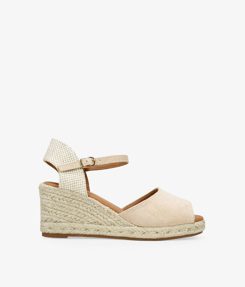 Sandalia beige con cuña de esparto vista de lado, con la tira al tobillo y la hebilla