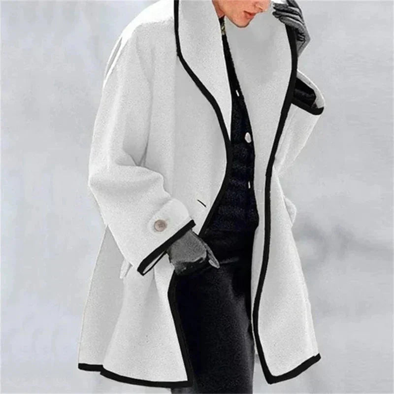 Mujer con el abrigo de invierno en blanco con ribete negro en los bordes y cuello amplio
