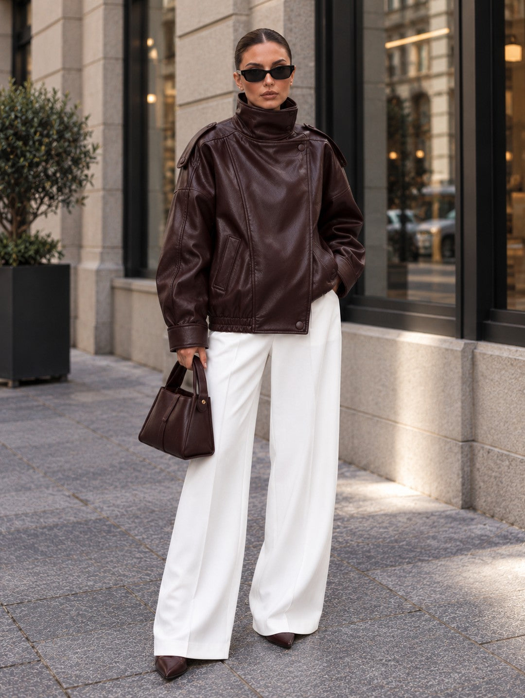 Cazadora efecto piel oversize en marrón rojizo con pantalón blanco ancho y bolso, de cuerpo entero